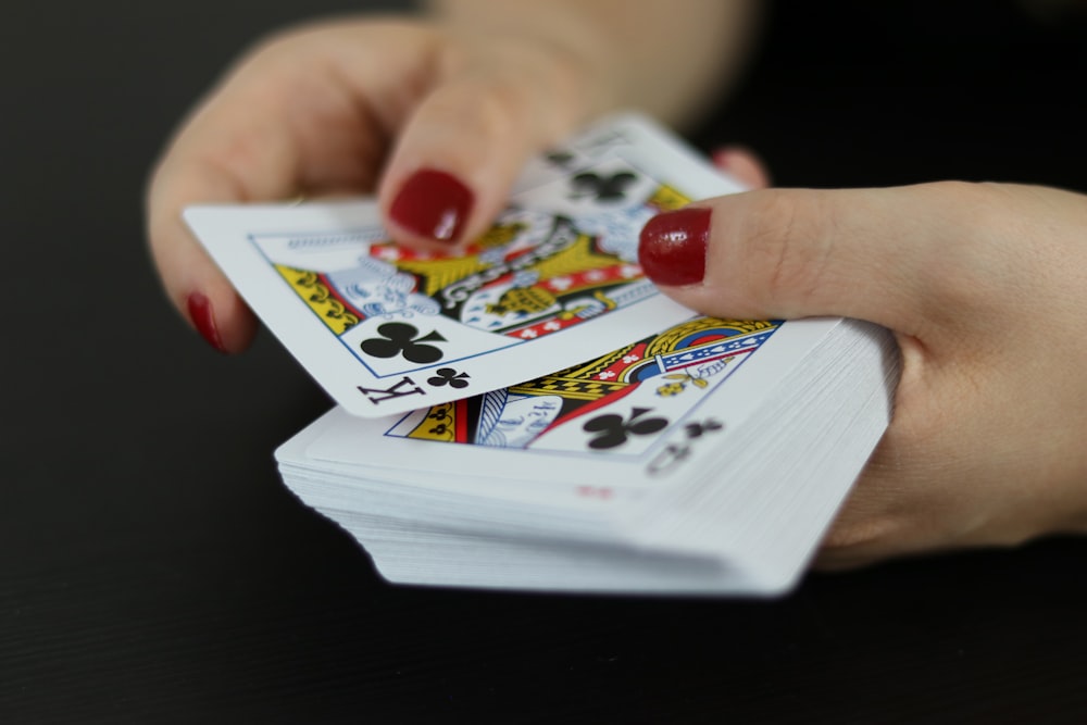 close-up photography of person holding playing cards