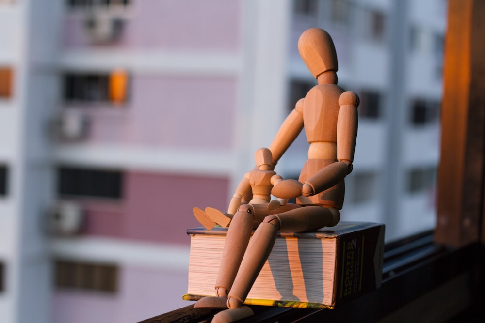 two manikin sitting on book