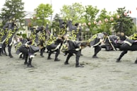 A dynamic dance group performing a colorful and synchronized routine outdoors.