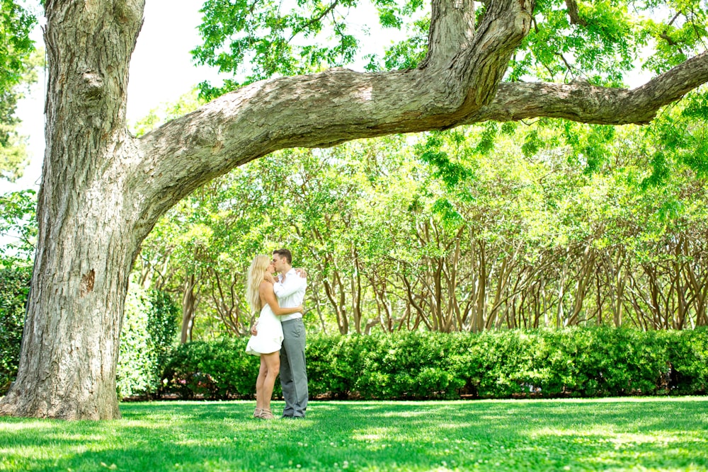 a man and a woman standing under a tree