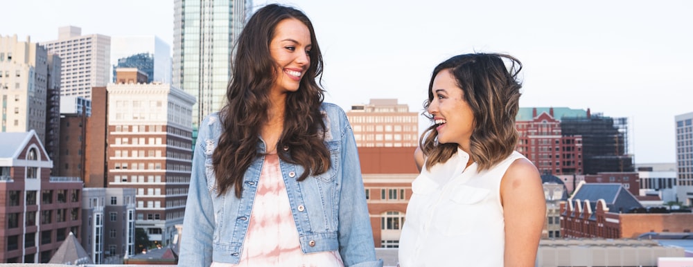 two women facing and both smiling