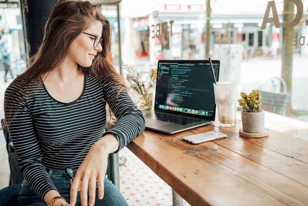 woman sits near laptop computer