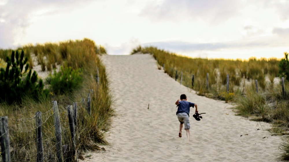 person wearing black shirt running on sand floor