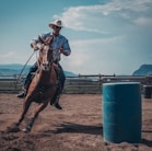 man in white cowboy hat riding a horse