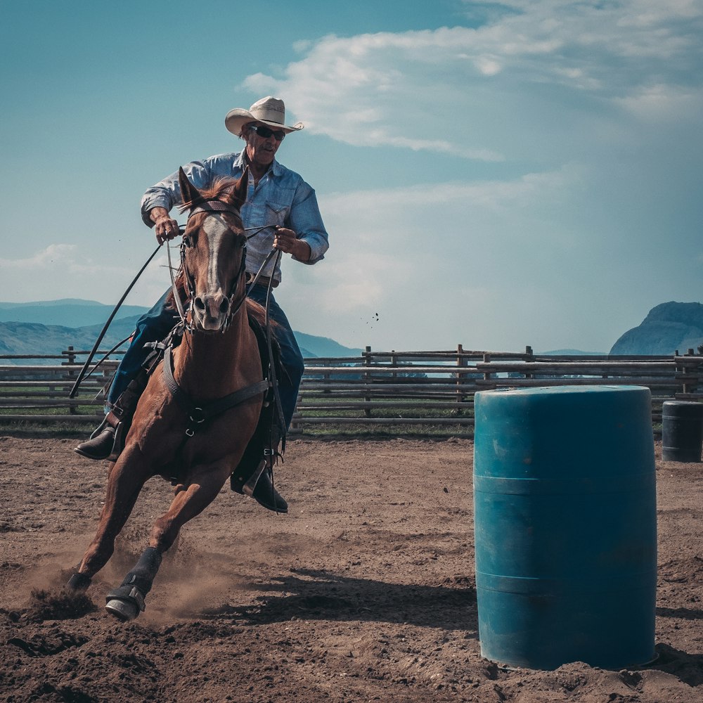 man in white cowboy hat riding a horse