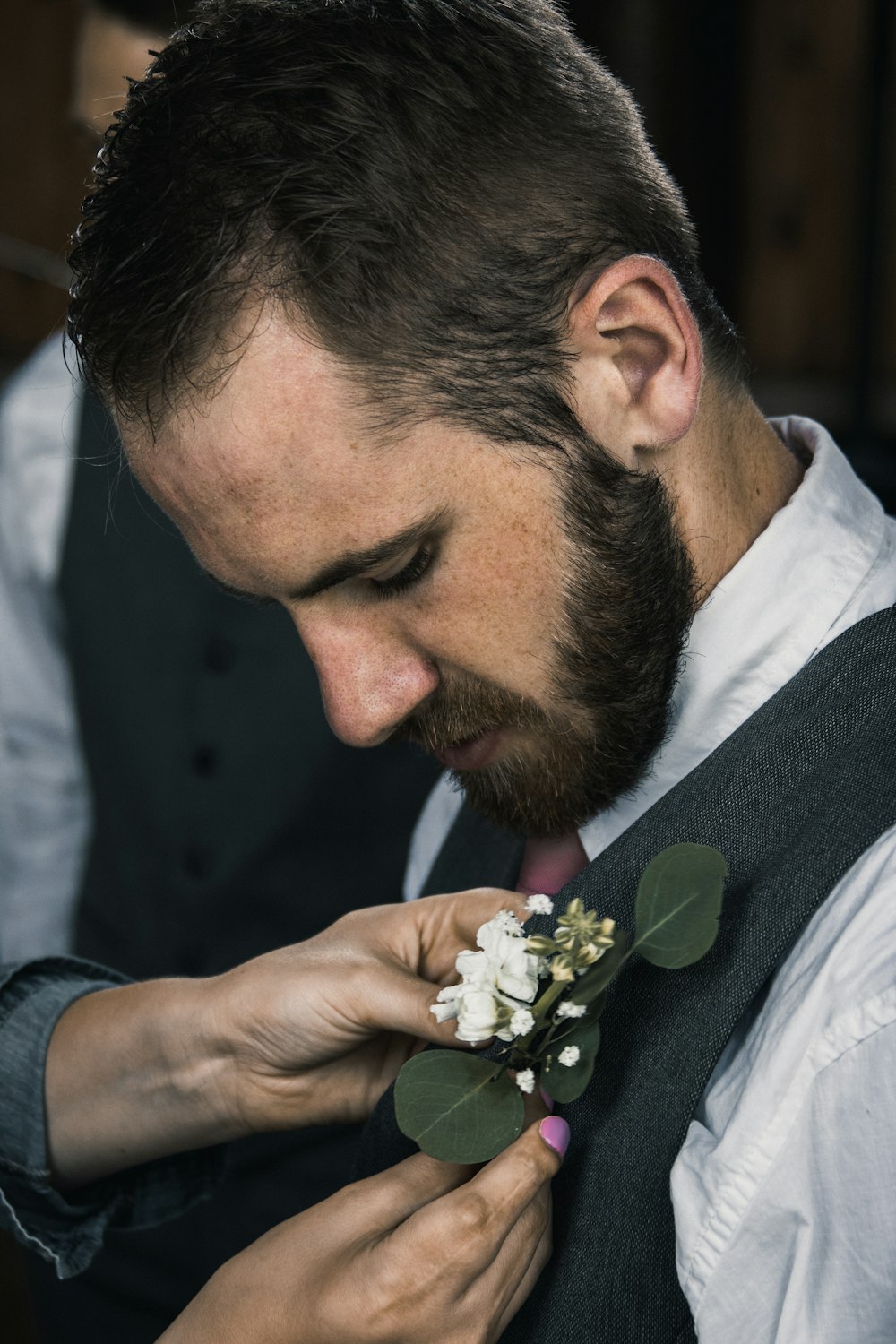 a man is putting a boutonniere on his tie