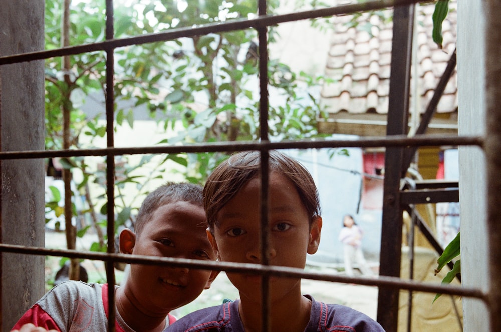 two toddlers behind window