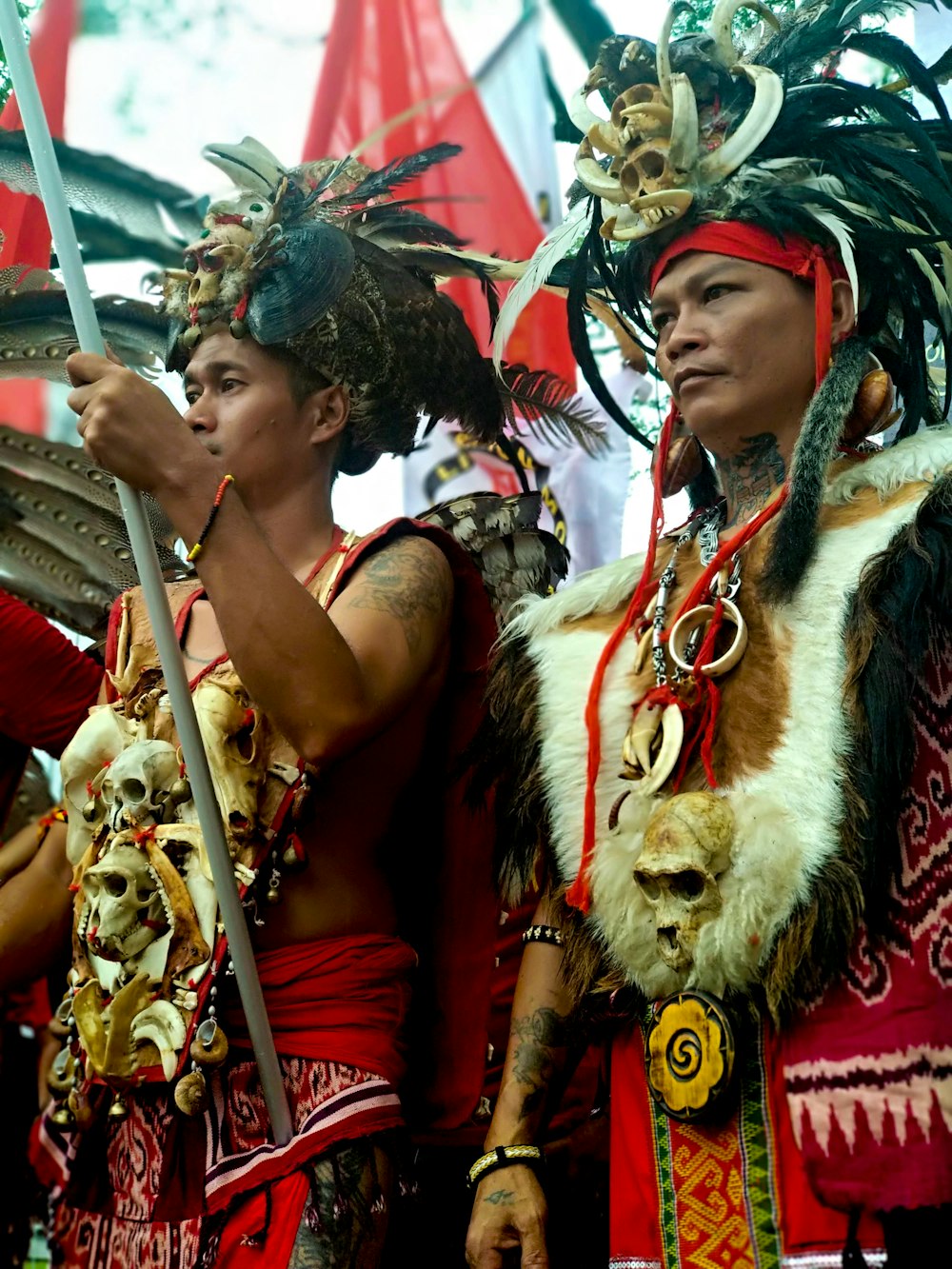 dois homens em pé vestindo trajes nativos americanos durante o dia