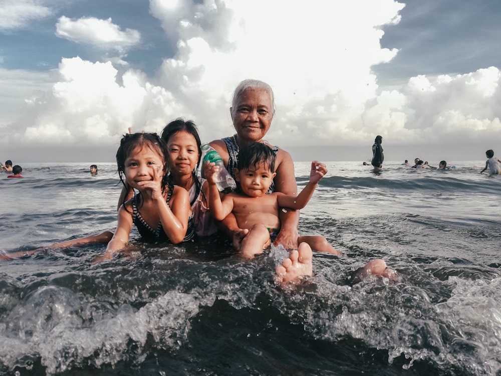 three children and man at the beach