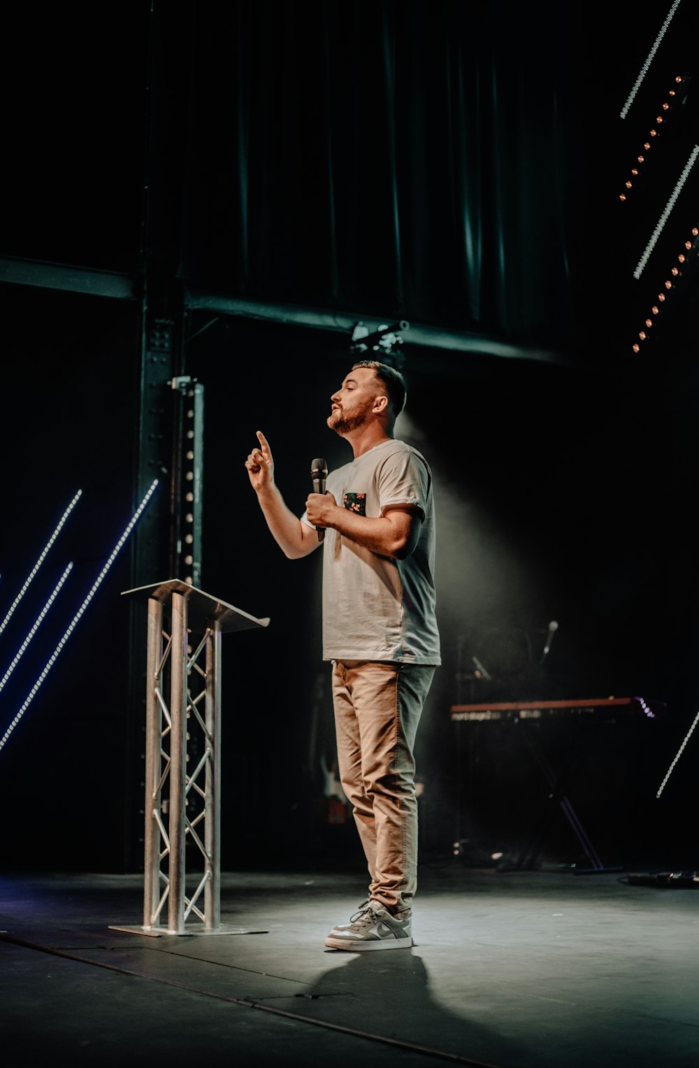 photography of standing man while holding microphone