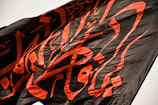 Detailed view of a black and gold wind banner with bold typography