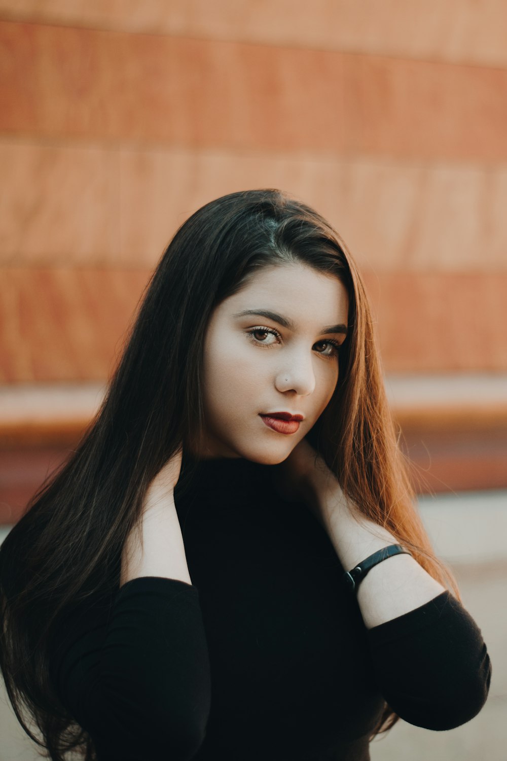 woman wearing black turtle-neck sweater with hands on her nape