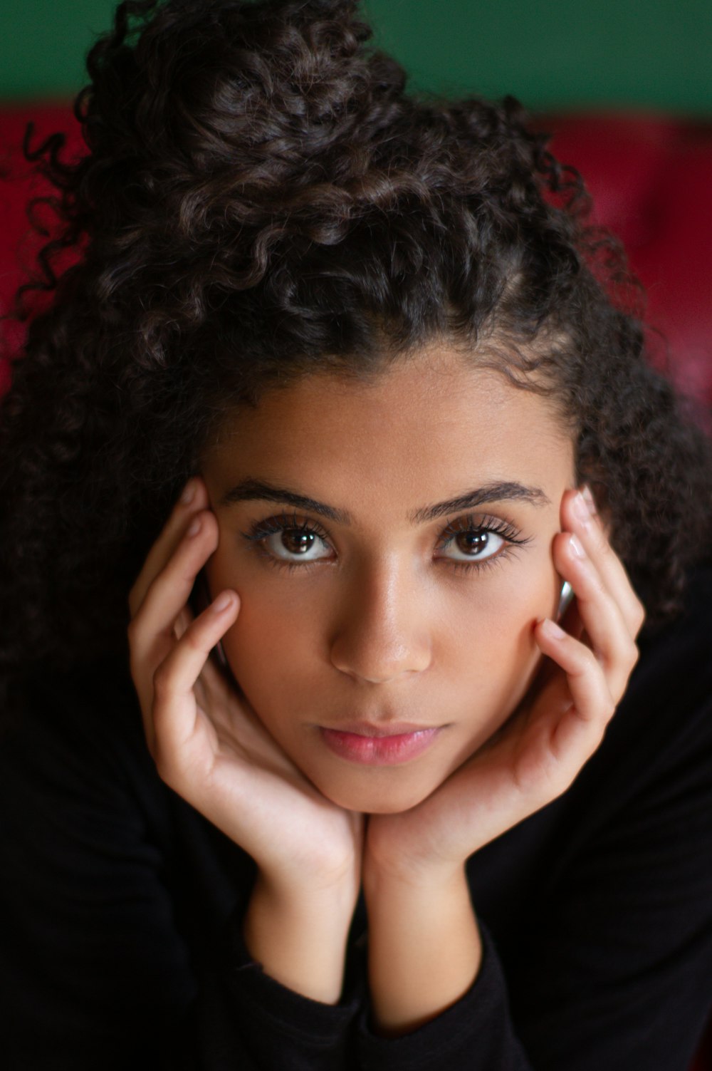 woman wearing black shirt with hands on her cheeks