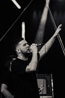 Ilker Karacam passionately singing on stage with dramatic lighting