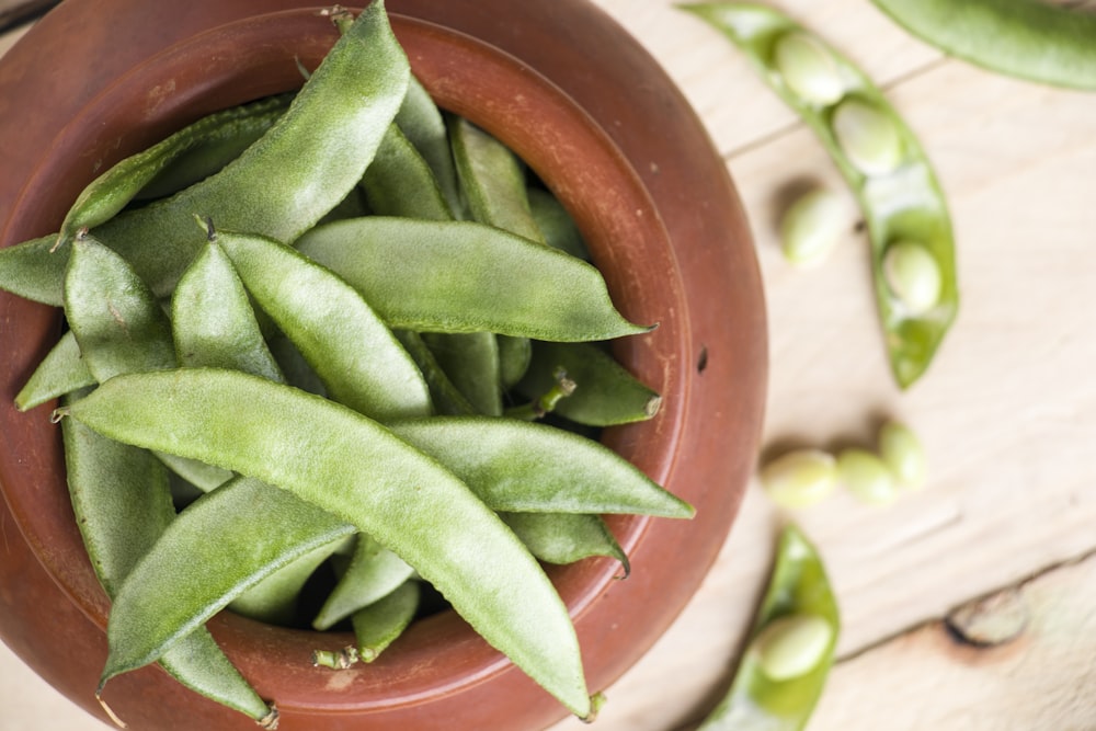 green snow peas in brown pot