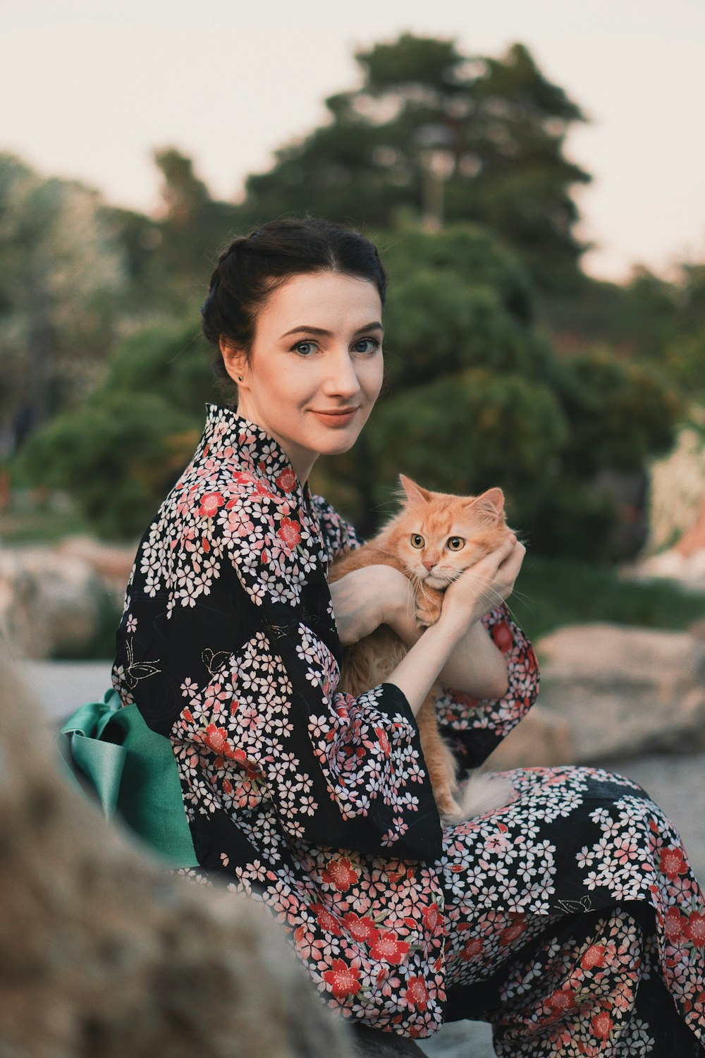 woman holding orange cat during daytime