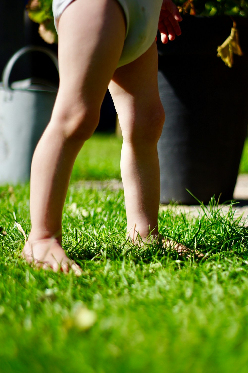 toddler wearing underwear standing on grass