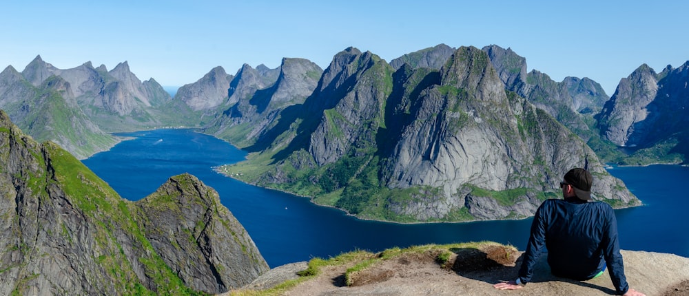 man sitting on mountain during daytime