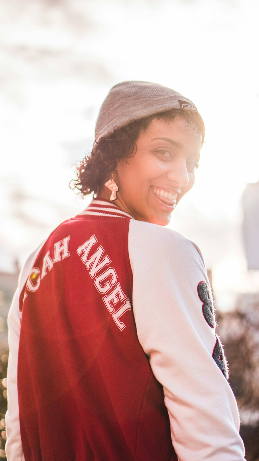 mujer sonriente con chaqueta roja y blanca