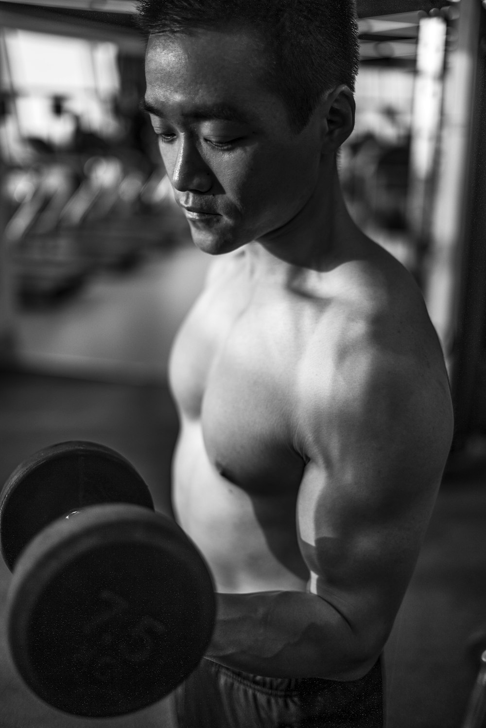 man lifting dumbbell inside gym