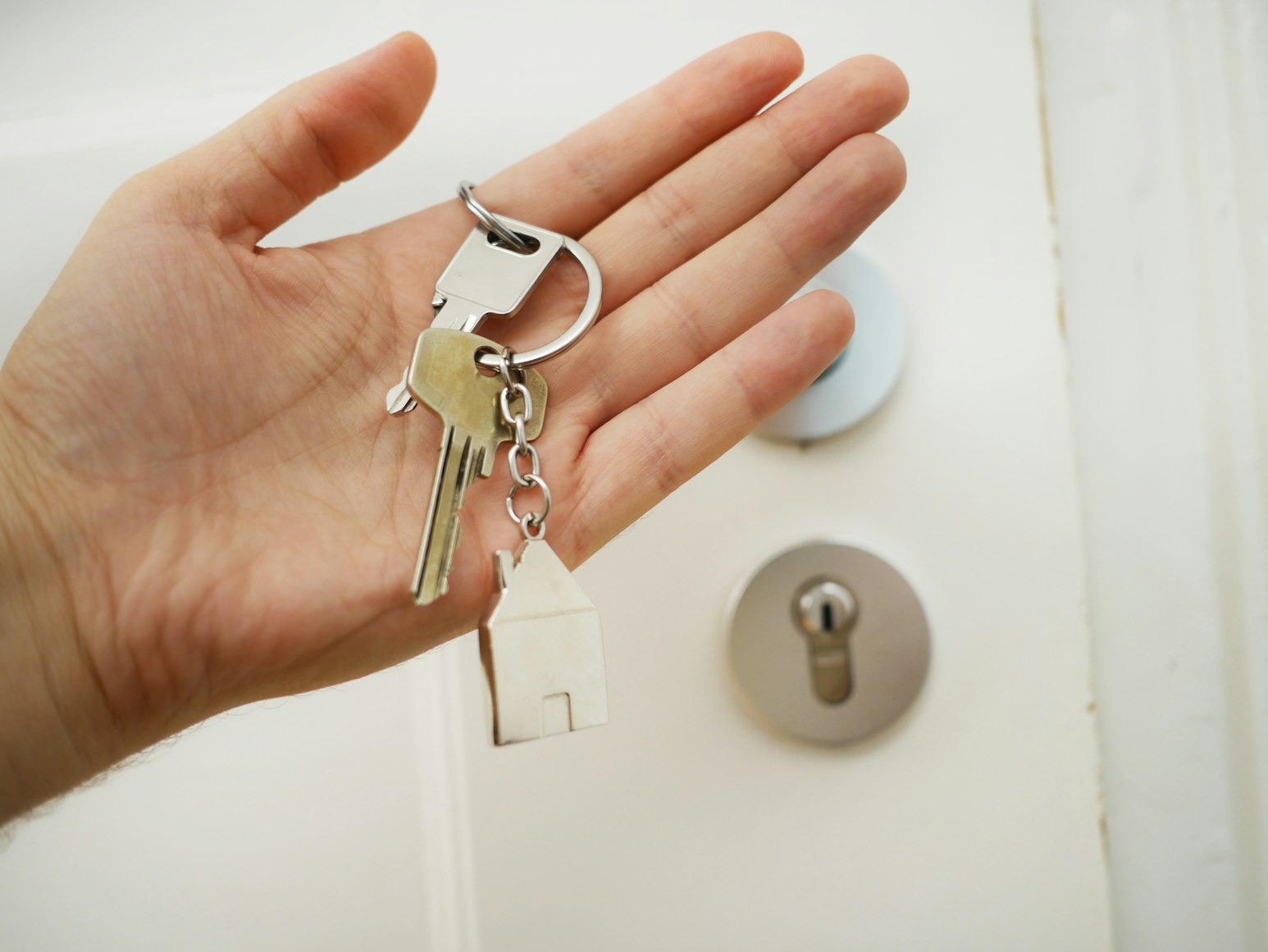 A person holding keys to a house.
