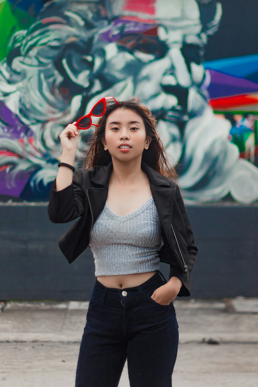 woman in gray crop top, black jacket, and black pants