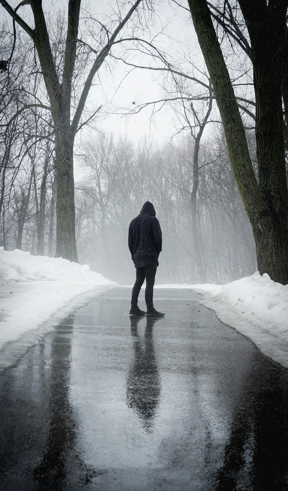 person wearing hoodie standing on road