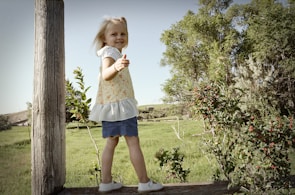 A young girl proudly showing her school project outdoors