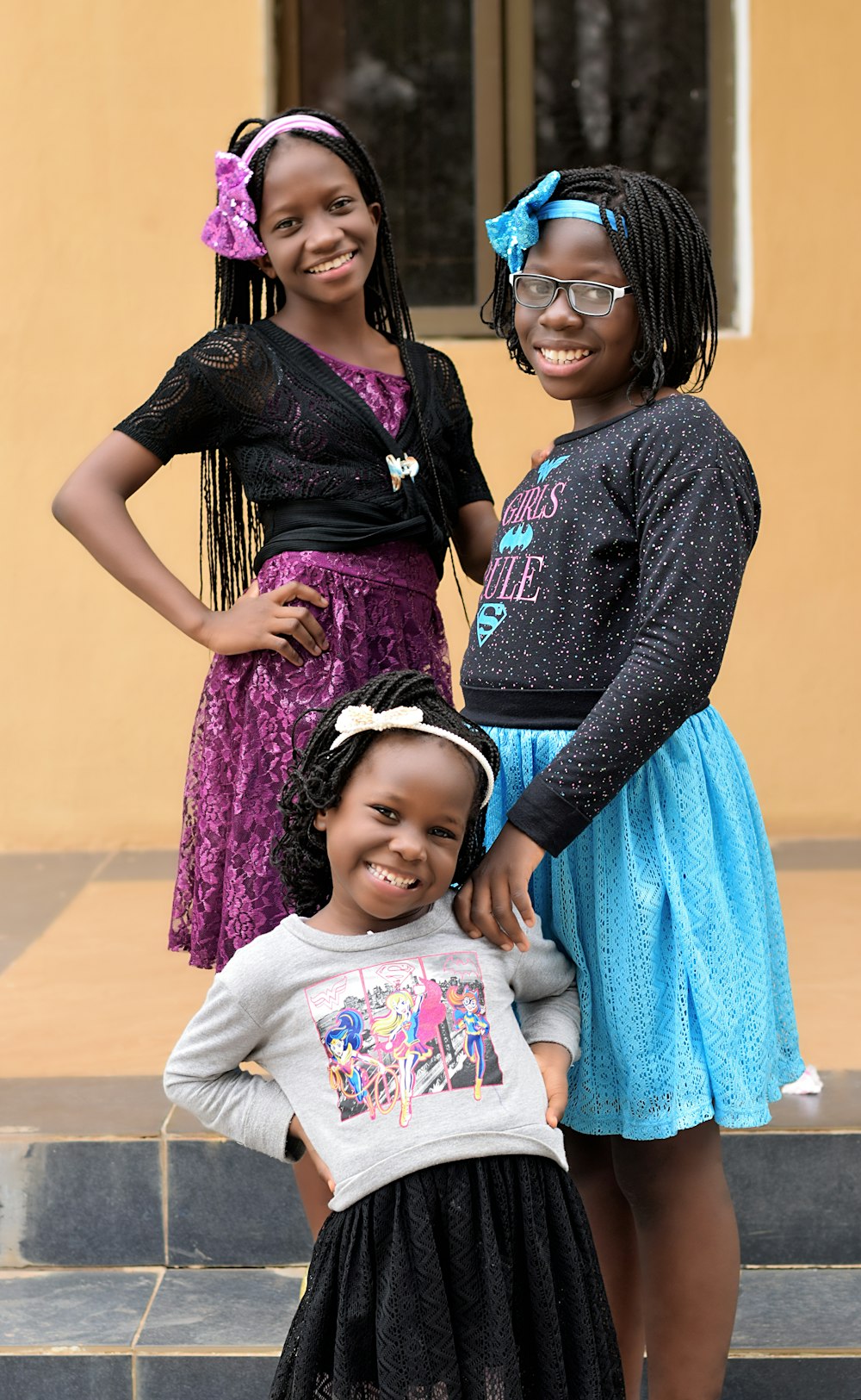 three girls standing near house