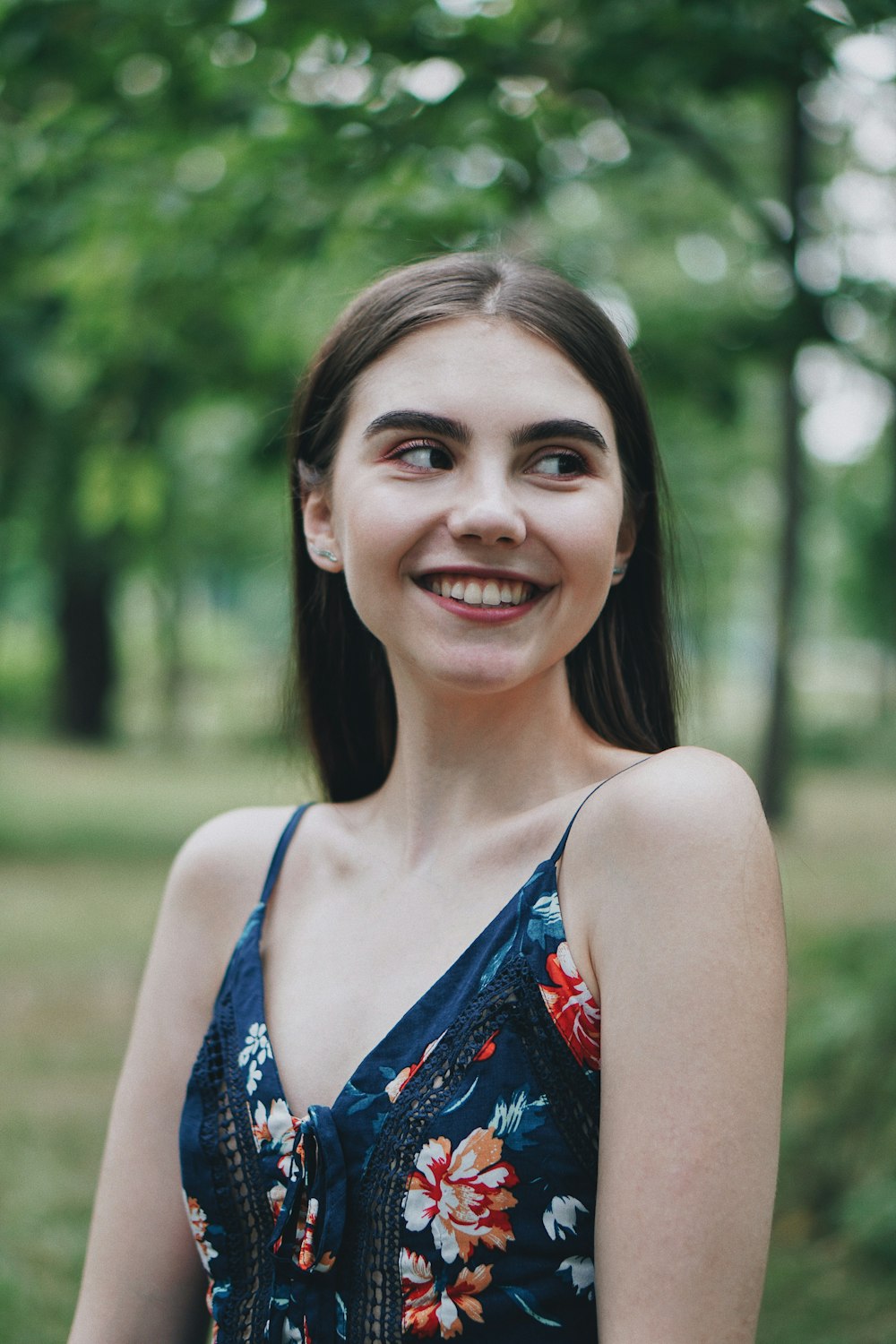 mulher sorridente vestindo top floral preto e laranja