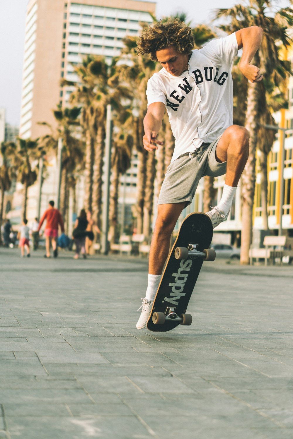 건물 근처 도로에서 스케이트를 타는 흰색과 검은색 티셔츠를 입은 남자