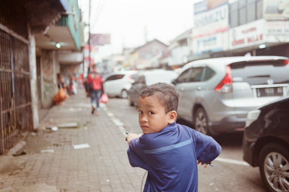 boy riding on bicycle beside road