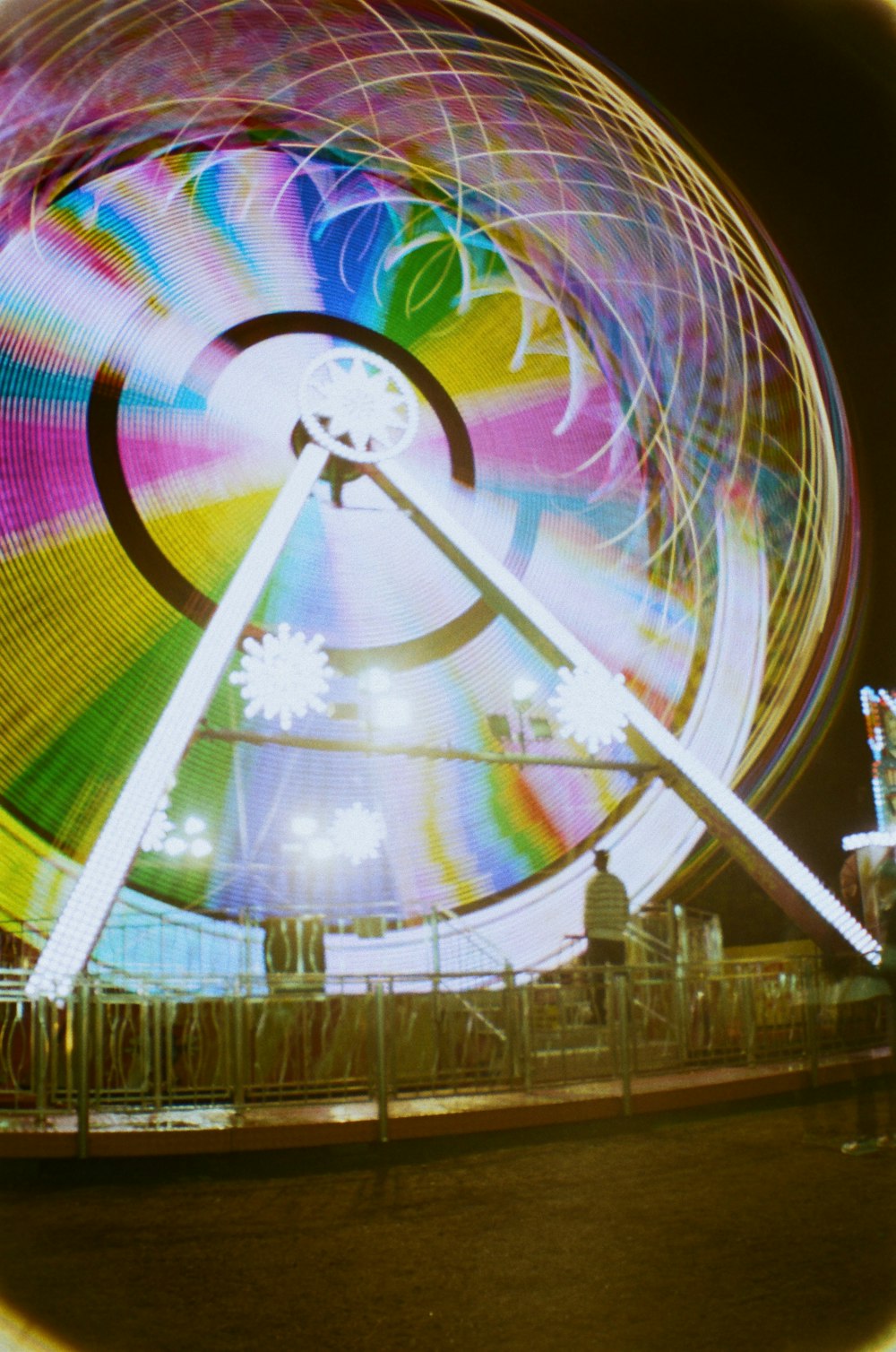 Ein Riesenrad bei Nacht mit einem Riesenrad im Hintergrund