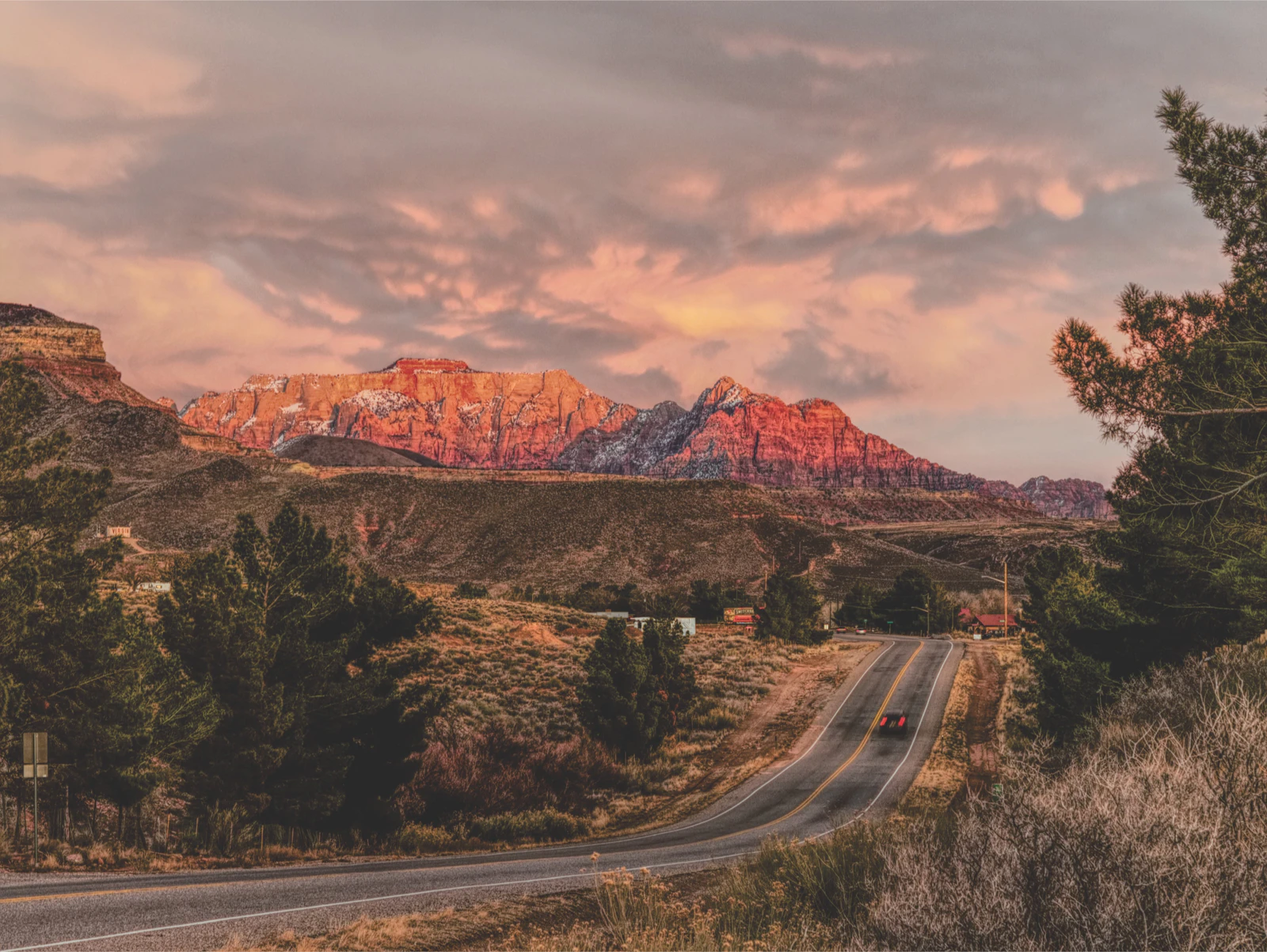 A car approaches Zion National Park on an open road