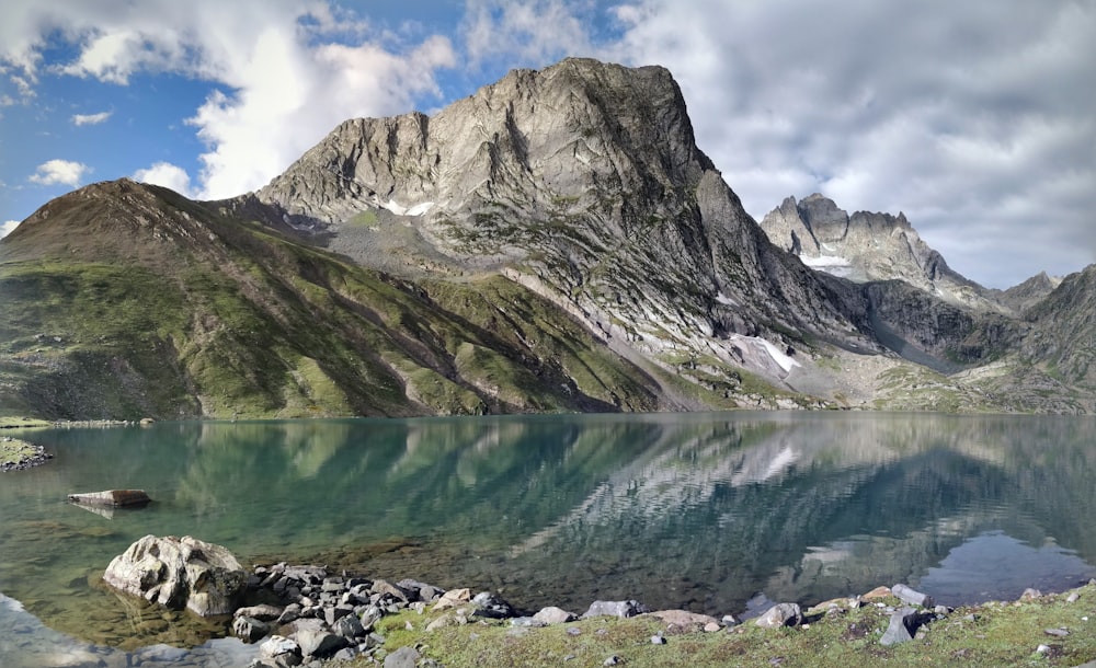 body of water near rocky mountain during daytime