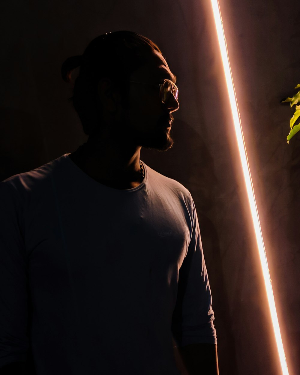 man standing by a turned-on orange light