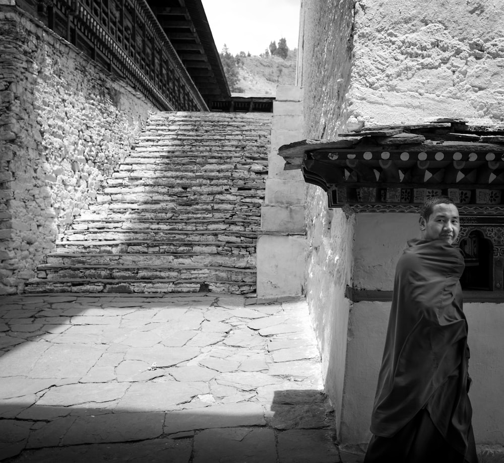 grayscale photography of man near stairs