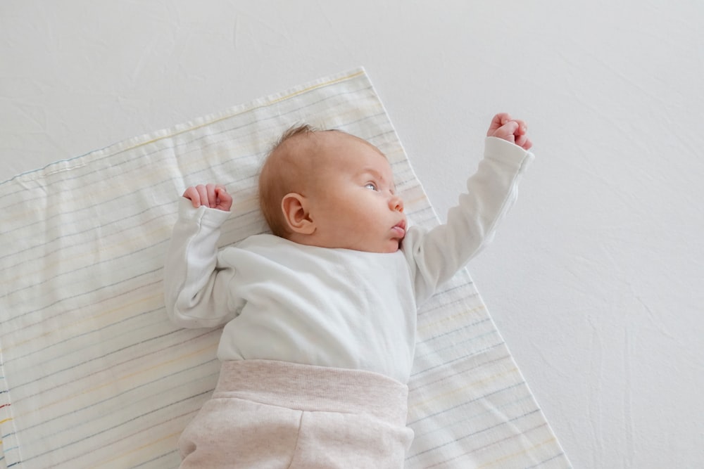 baby wearing white long-sleeved shirt