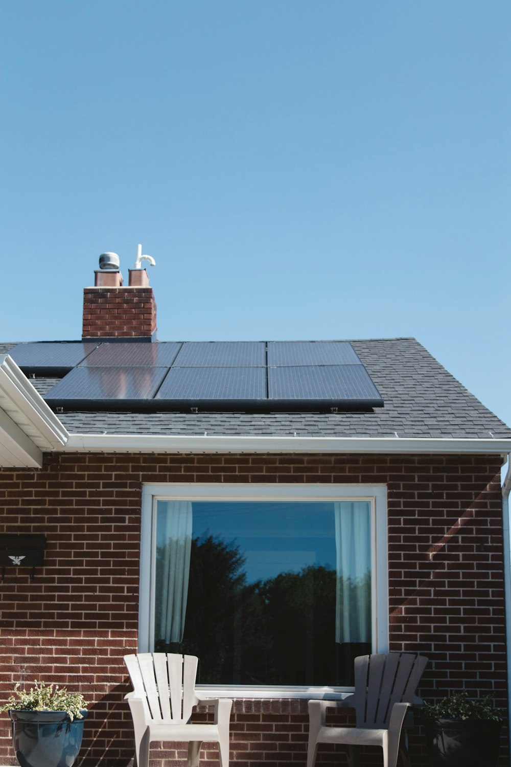 brown brick house with solar panels on roof