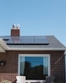 brown brick house with solar panels on roof