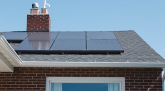 brown brick house with solar panels on roof