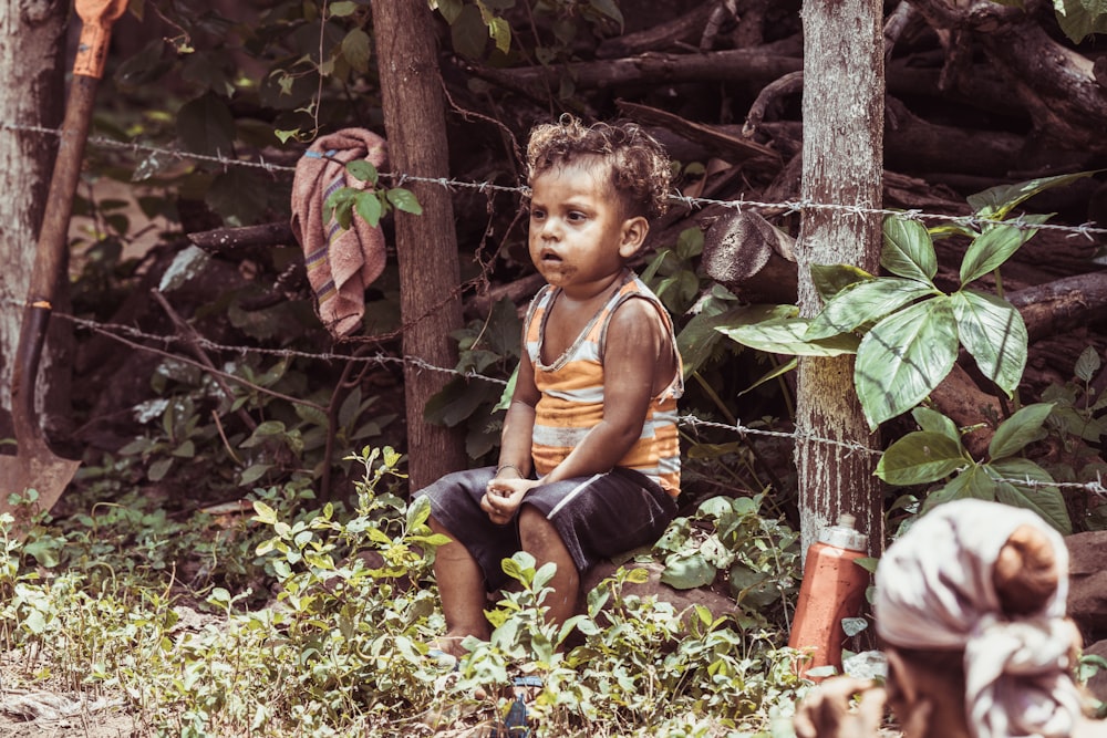 boy sitting on barbwire