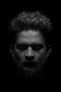 Detailed shot of a sculpted beard with sharp edges and defined lines under warm lighting.