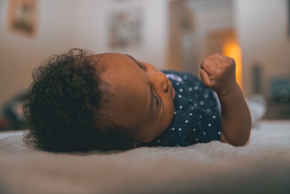 baby wearing blue and white polka-dotted shirt