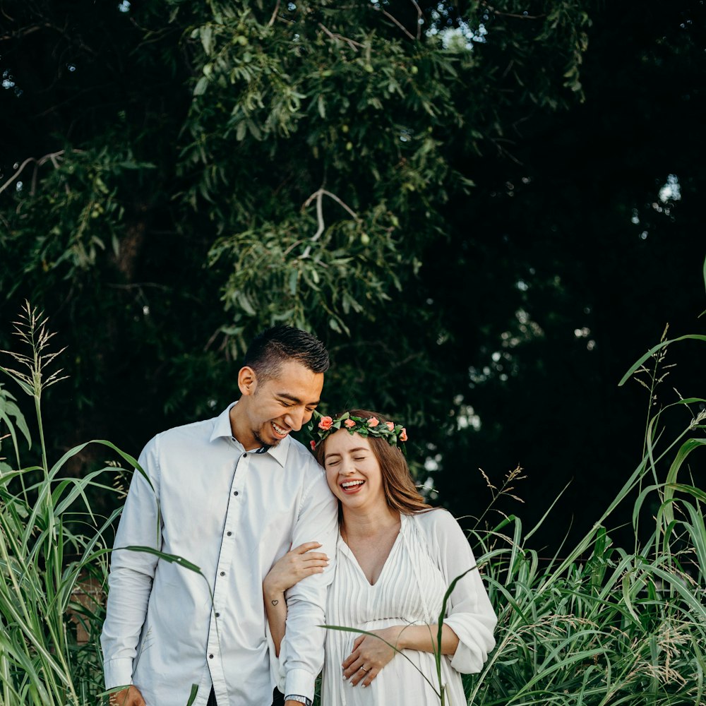 smiling man and woman standing beside grass