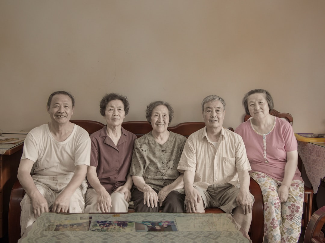 four persons sit on sofa in front empty coffee table