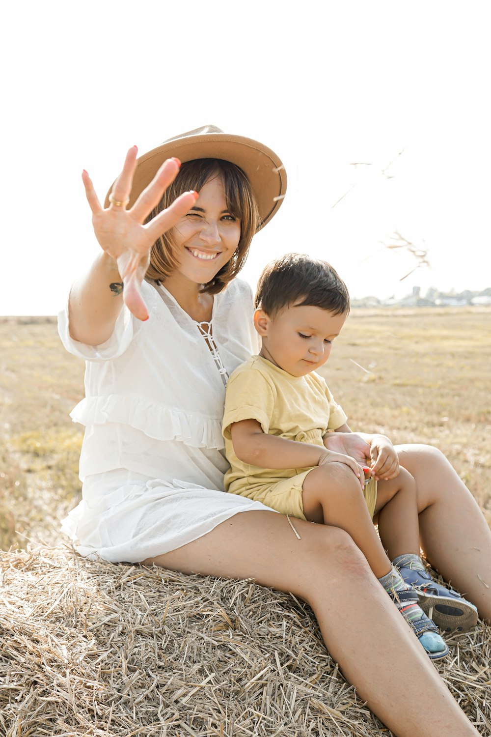 woman and boy sitting on hay bale