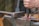 A hand is holding a chisel and hammering a red-hot piece of metal on an anvil, illustrating metalworking in progress.