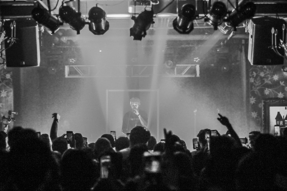 grayscale photo of man performing on stage