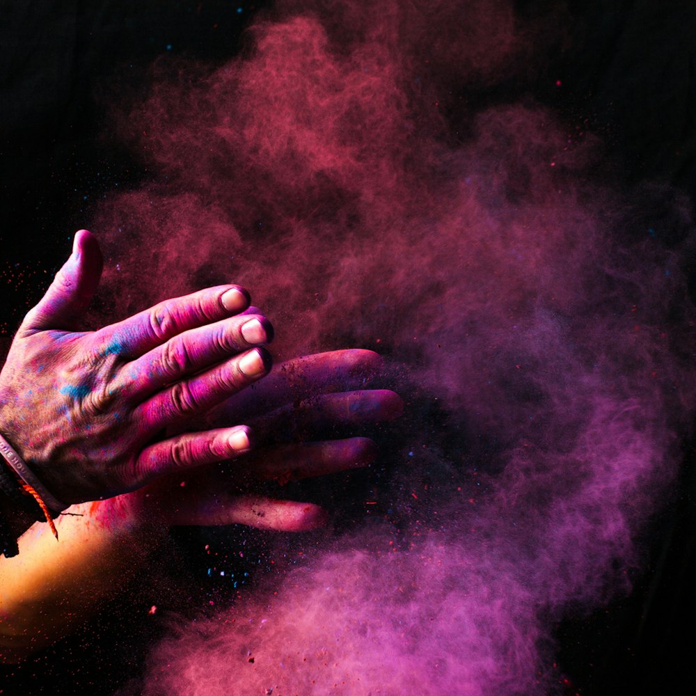 person clapping pink smoke